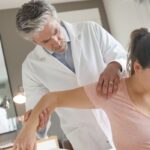 Physiotherapist helping patient with shoulder injury