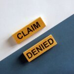 Insurance Claim Denial, 'Claim denied' words on wooden blocks.