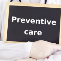 Doctor shows information on blackboard: preventive care